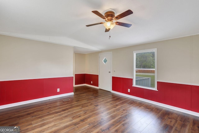 unfurnished room with wood finished floors, baseboards, ceiling fan, a wainscoted wall, and vaulted ceiling
