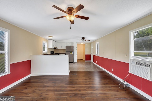 kitchen featuring a sink, dark wood finished floors, freestanding refrigerator, a ceiling fan, and baseboards