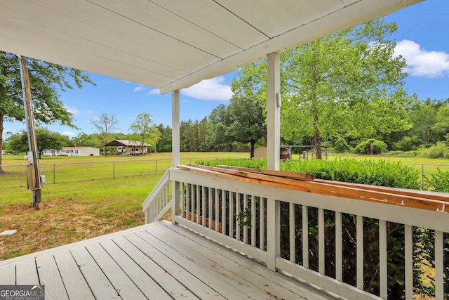 wooden deck featuring a lawn and fence