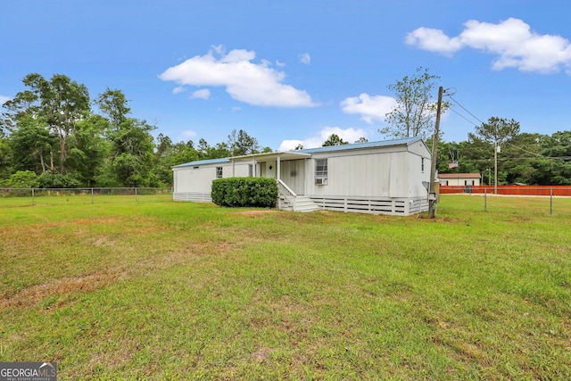 rear view of property with a yard and fence