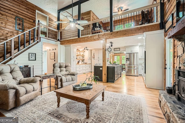5419 Tyree Rd, Winston, GA 30187 - living room with stairway, ceiling fan, light wood-style floors, and a towering ceiling