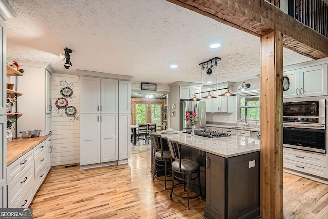 5419 Tyree Rd, Winston, GA 30187 - kitchen featuring stainless steel appliances, a textured ceiling, plenty of natural light, and light wood-style floors