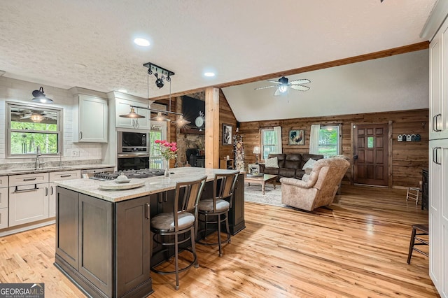 5419 Tyree Rd, Winston, GA 30187 - kitchen with wood walls, appliances with stainless steel finishes, a sink, and light wood-style flooring