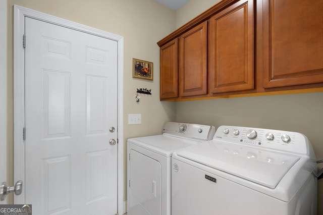 clothes washing area with cabinet space and washing machine and dryer