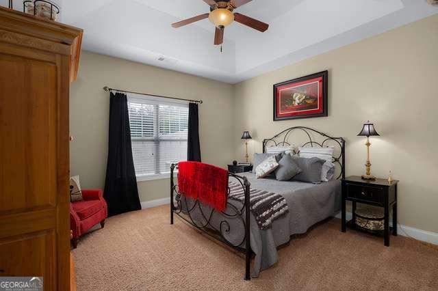 bedroom featuring baseboards, light carpet, and ceiling fan