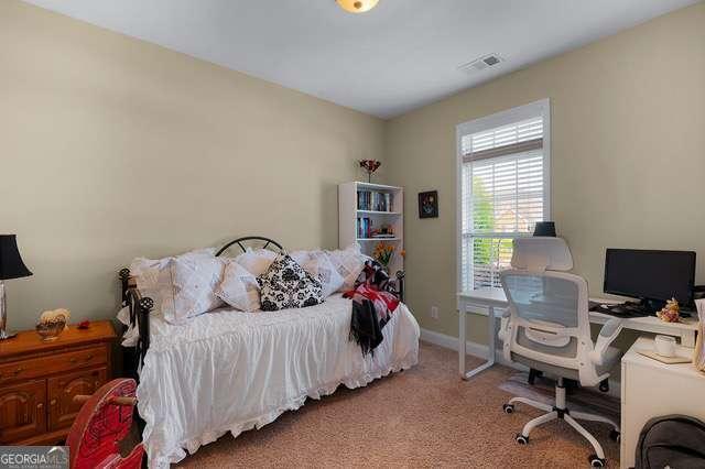 bedroom with carpet floors, baseboards, and visible vents