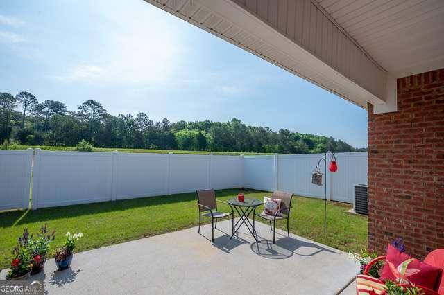 view of patio featuring central air condition unit, a fenced backyard, and outdoor dining space