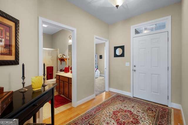 entryway with baseboards and light wood finished floors