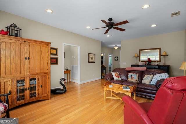 living area with ceiling fan, visible vents, baseboards, light wood finished floors, and recessed lighting