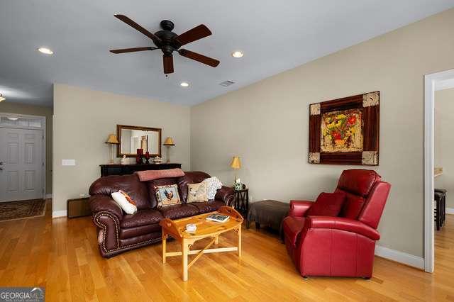 living room featuring a ceiling fan, baseboards, recessed lighting, and wood finished floors