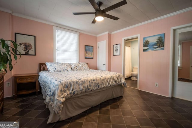 bedroom with crown molding, baseboards, ceiling fan, dark tile patterned flooring, and ensuite bath
