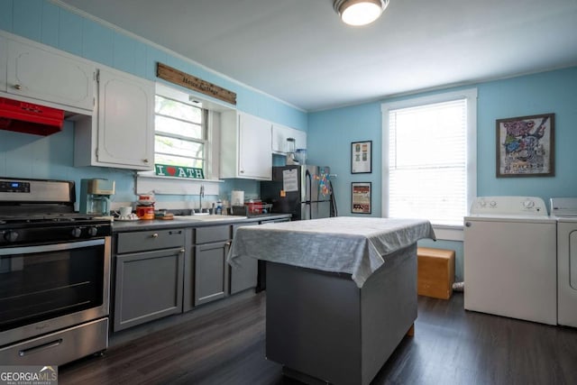 kitchen with appliances with stainless steel finishes, a sink, separate washer and dryer, gray cabinets, and dark wood-type flooring
