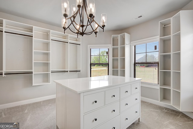 spacious closet with light colored carpet, a chandelier, and visible vents