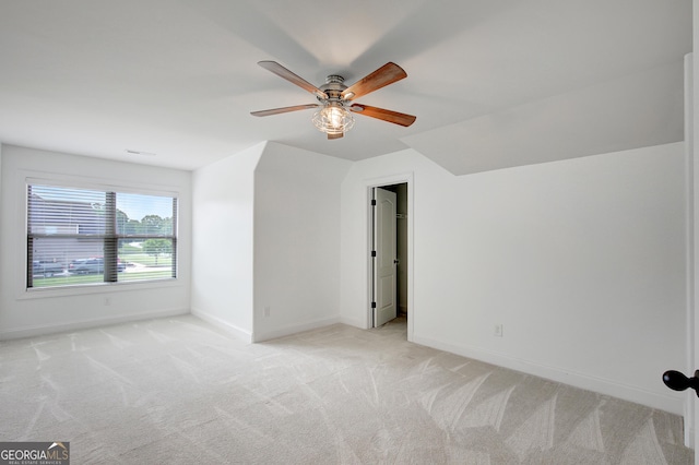 additional living space featuring baseboards, ceiling fan, and light carpet
