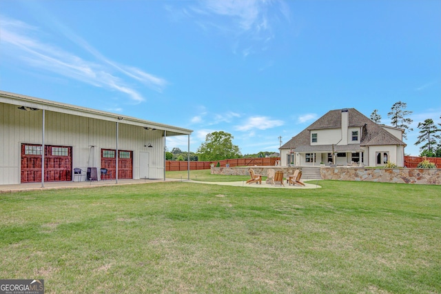 view of yard with fence, an outbuilding, an outdoor structure, and a patio