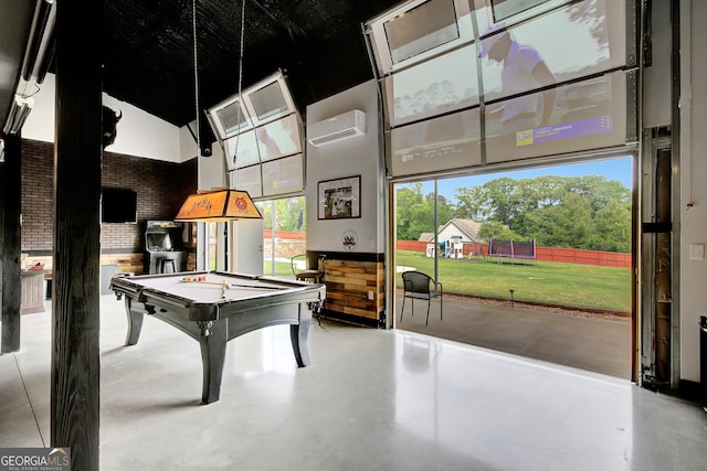 game room with finished concrete flooring, billiards, a high ceiling, and a wall unit AC