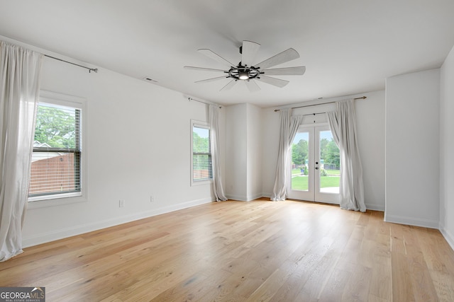 empty room featuring a ceiling fan, baseboards, french doors, and light wood-style floors