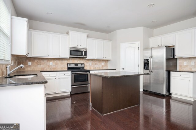 108 Franklin St, Braselton, GA 30517 - kitchen featuring a kitchen island, white cabinets, tasteful backsplash, a sink, and appliances with stainless steel finishes