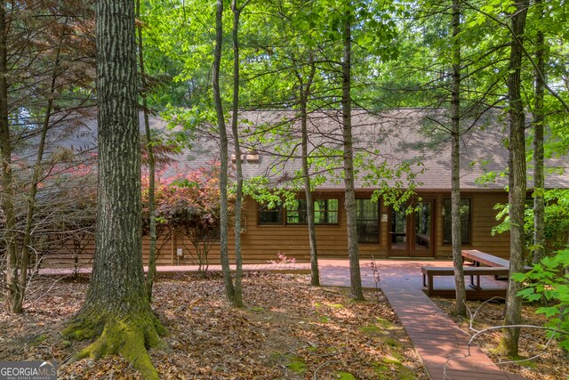 back of property featuring french doors, a patio, and a shingled roof