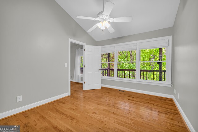 empty room featuring a ceiling fan, baseboards, wood finished floors, and high vaulted ceiling