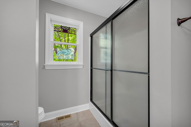 bathroom featuring visible vents, tile patterned floors, a stall shower, and toilet