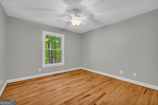 unfurnished room with baseboards, ceiling fan, and wood finished floors