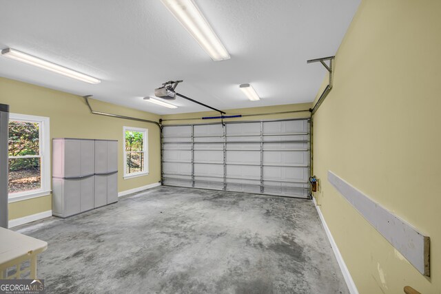 garage with baseboards and a garage door opener