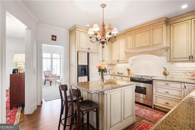 45 Paces W Dr NW, Atlanta, GA 30327 - kitchen with paneled refrigerator, dark wood-style flooring, cream cabinets, stainless steel gas stove, and a notable chandelier