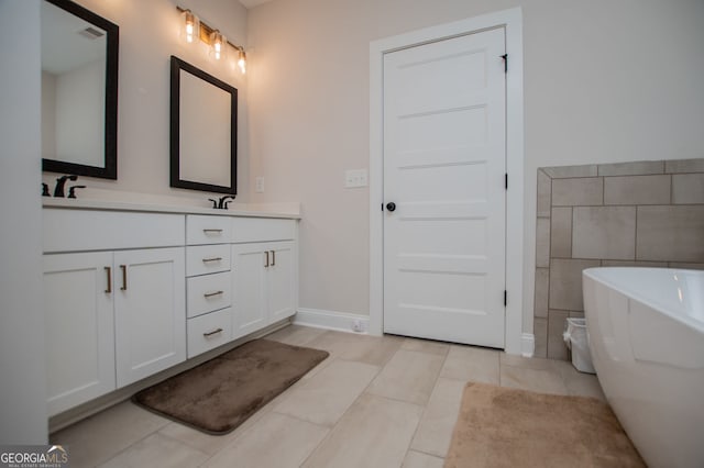 full bath featuring double vanity, a freestanding tub, visible vents, and tile patterned flooring