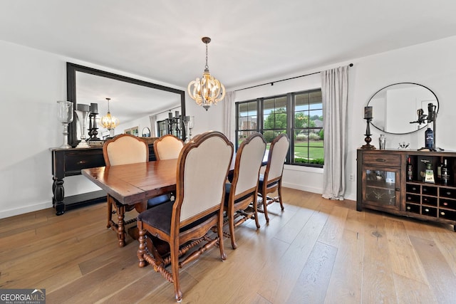 dining space featuring an inviting chandelier, baseboards, and hardwood / wood-style flooring