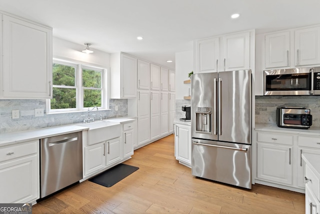kitchen featuring white cabinets, stainless steel appliances, and tasteful backsplash