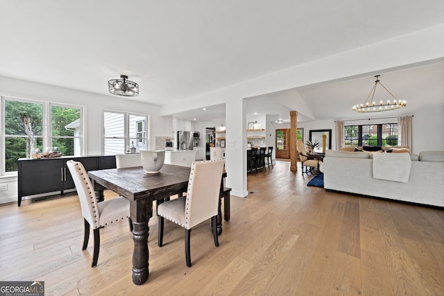 dining space featuring an inviting chandelier and light wood-style flooring