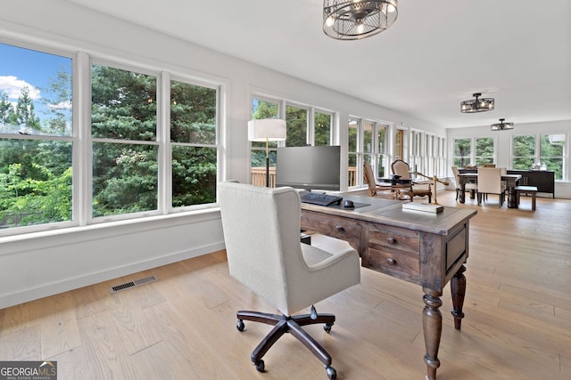 office area with light wood-style floors, baseboards, an inviting chandelier, and visible vents