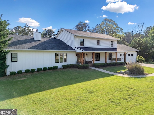view of front facade featuring a porch, a chimney, a front yard, a garage, and concrete driveway