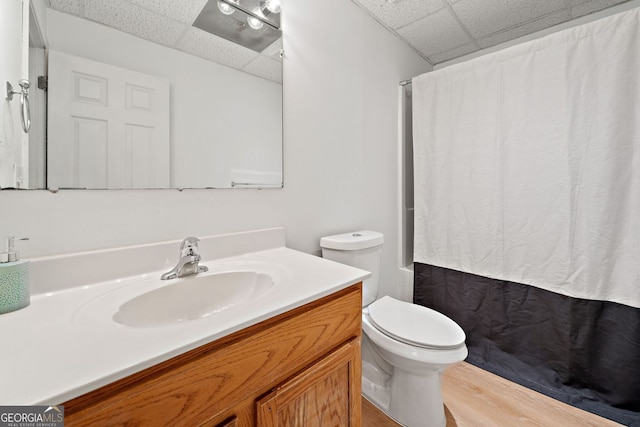 bathroom featuring vanity, a drop ceiling, toilet, and wood finished floors