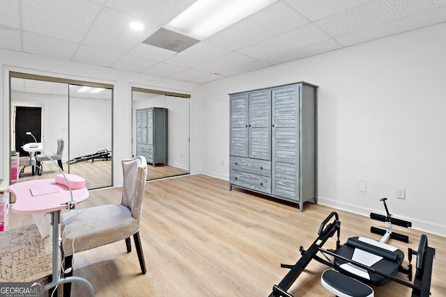 office with baseboards, light wood finished floors, and a drop ceiling