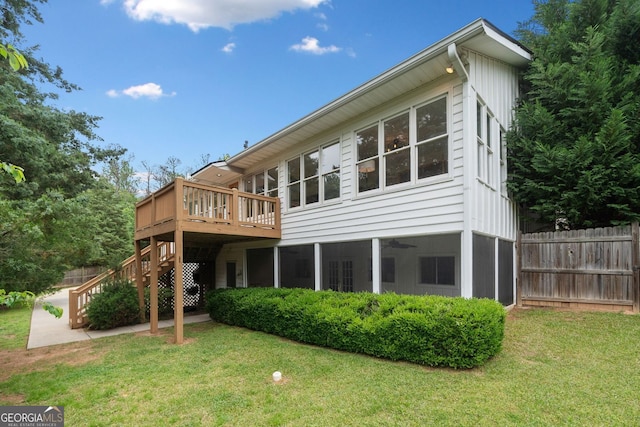 back of house featuring a yard, a deck, and fence