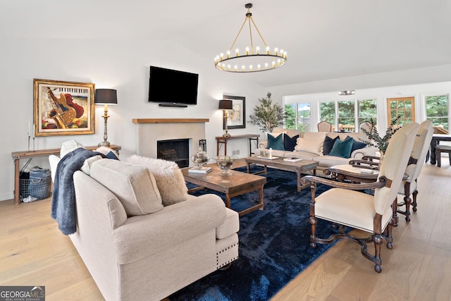 living area featuring plenty of natural light, vaulted ceiling, and wood finished floors