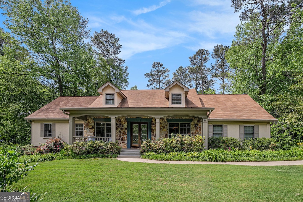 351 Old Orchard Ct, Marietta, GA 30068 - cape cod home featuring stone siding, covered porch, and a front yard