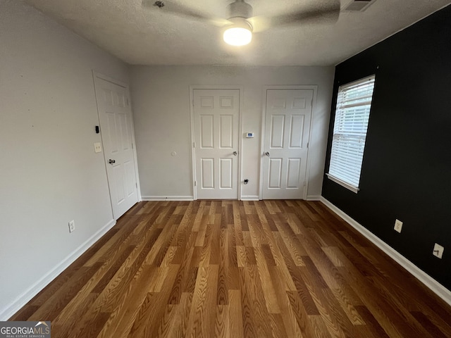 2353 Wellington Cir, Lithonia, GA 30058 - unfurnished bedroom with baseboards, a textured ceiling, and wood finished floors