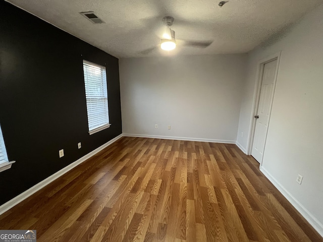 2353 Wellington Cir, Lithonia, GA 30058 - spare room with visible vents, wood finished floors, baseboards, a textured ceiling, and a ceiling fan