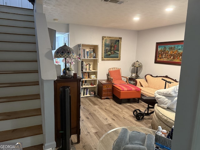 2353 Wellington Cir, Lithonia, GA 30058 - living area with a textured ceiling, visible vents, light wood-type flooring, stairway, and recessed lighting
