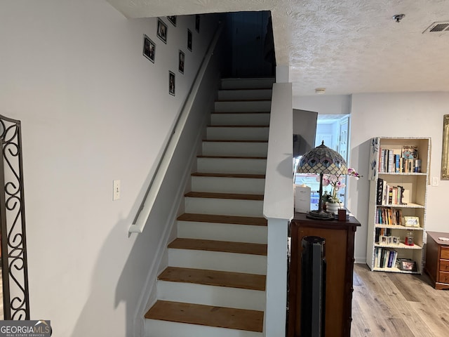 2353 Wellington Cir, Lithonia, GA 30058 - stairway with visible vents, a textured ceiling, and wood finished floors
