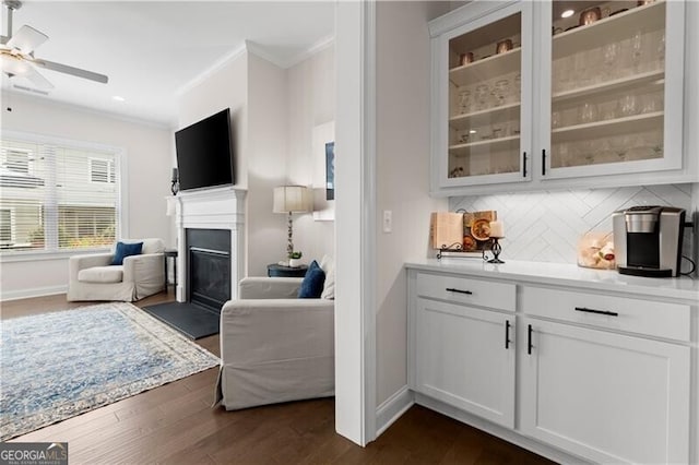 1074 Heyward Way, Alpharetta, GA 30009 - bar featuring a glass covered fireplace, ornamental molding, backsplash, and dark wood-type flooring