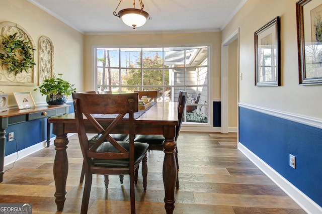dining area with crown molding, baseboards, and wood finished floors