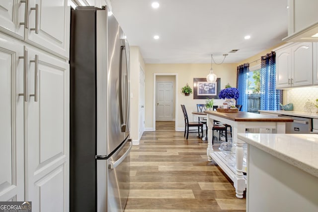 kitchen with decorative backsplash, appliances with stainless steel finishes, white cabinets, recessed lighting, and light wood-style flooring