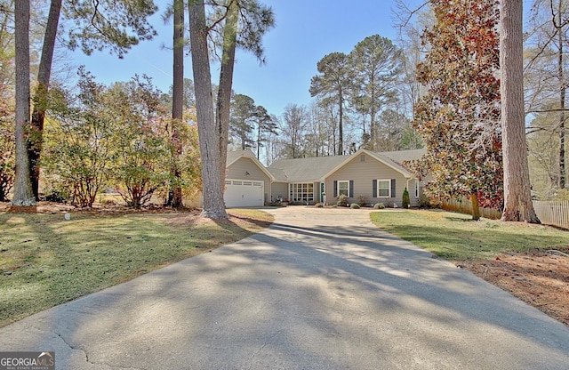 view of front of property featuring a garage, a front lawn, and driveway
