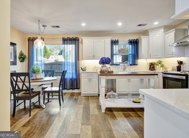 kitchen featuring visible vents, range, white cabinets, and a wealth of natural light