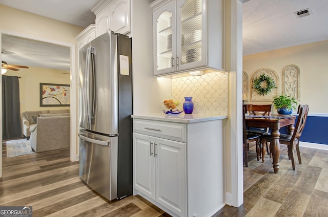kitchen featuring visible vents, freestanding refrigerator, light wood-style floors, light countertops, and white cabinets