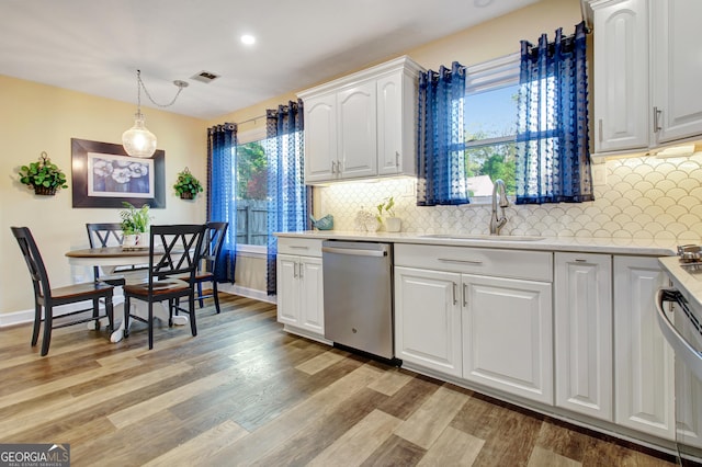 kitchen featuring light countertops, light wood-type flooring, a sink, and dishwasher